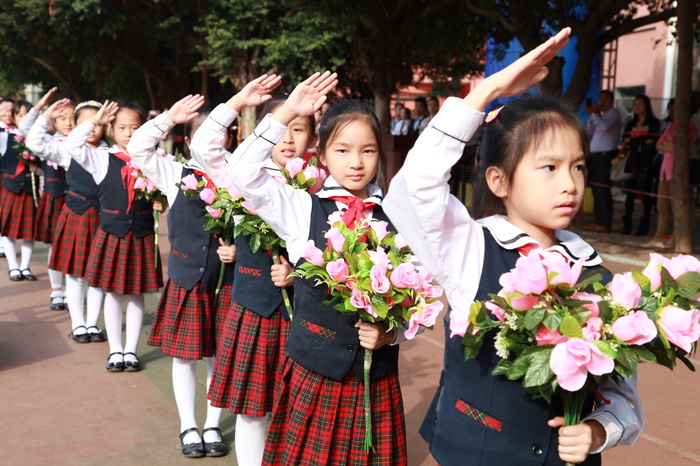 04、圖為鮮花隊(duì)的同學(xué)在升國旗儀式時(shí)向國旗敬禮